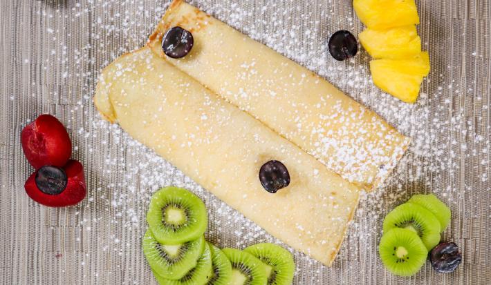 Crepe with fresh fruits and icing sugar